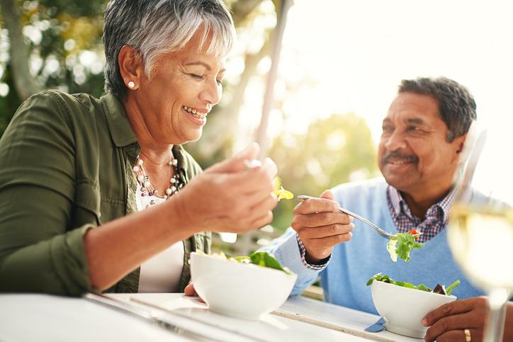 man and woman eating salad