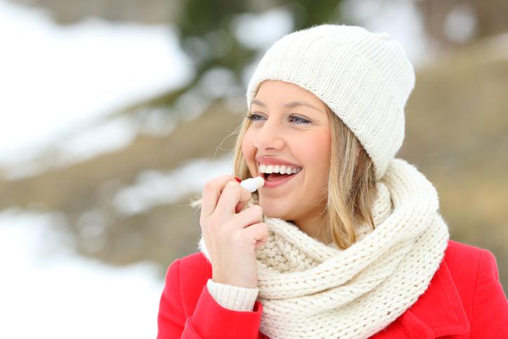 woman putting on chapstick