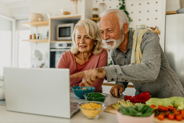 couple cooking, looking at computer