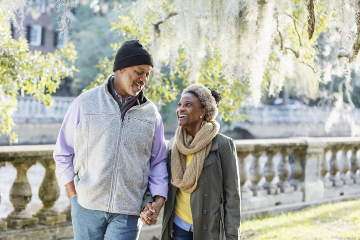 man and woman walking in park