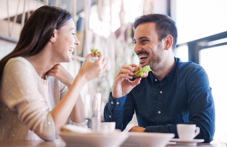 man and woman eating in cafe