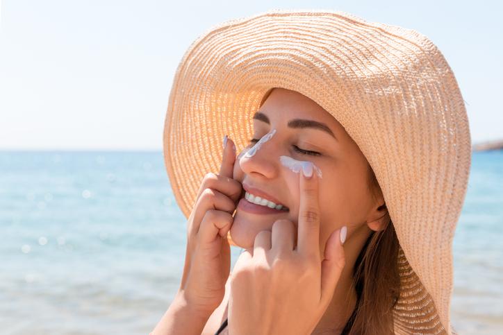 woman applying sunscreen at beach