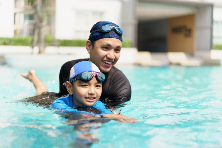 man and boy swimming in pool