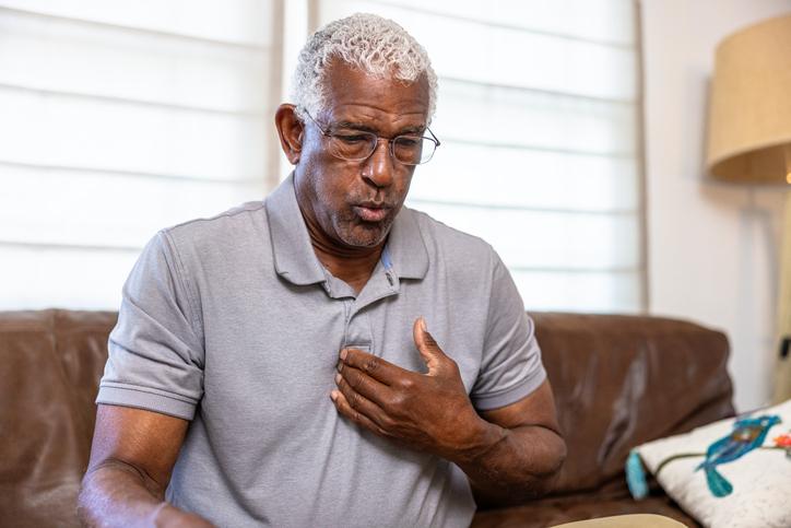 man on couch pointing to chest