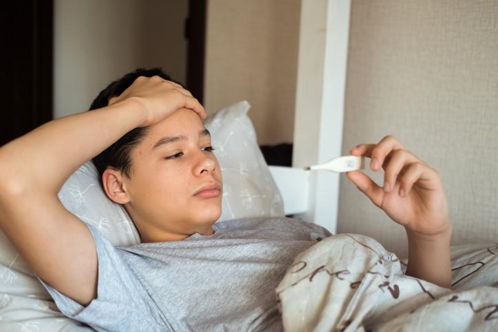 teenager laying down checking temperature