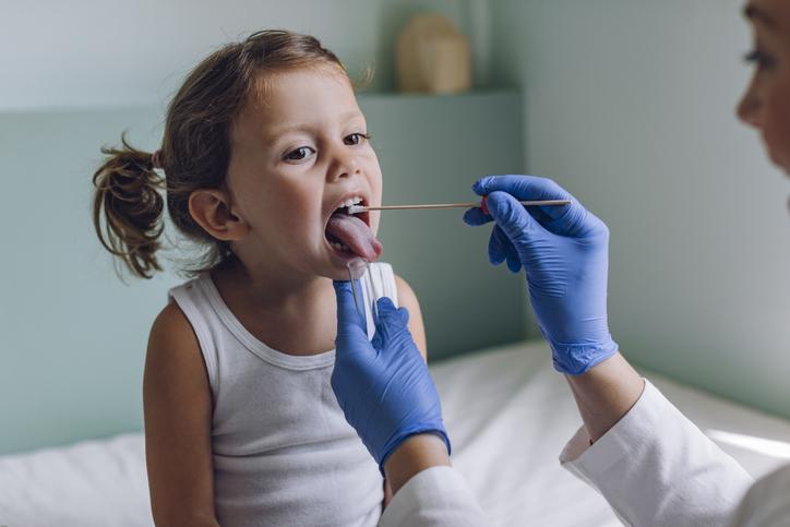 doctor checking child's throat