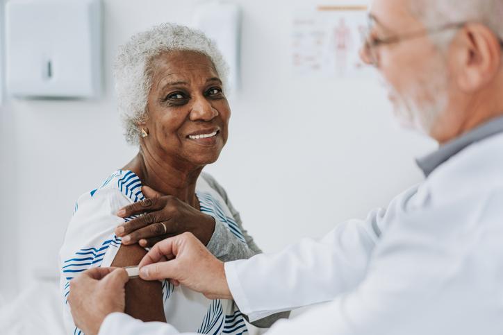 doctor putting band aid on woman