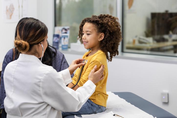 doctor listening to young girl's heart