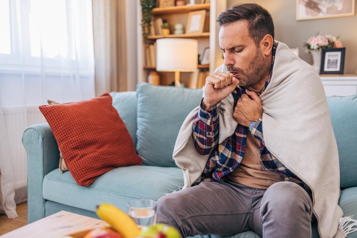 man coughing on couch