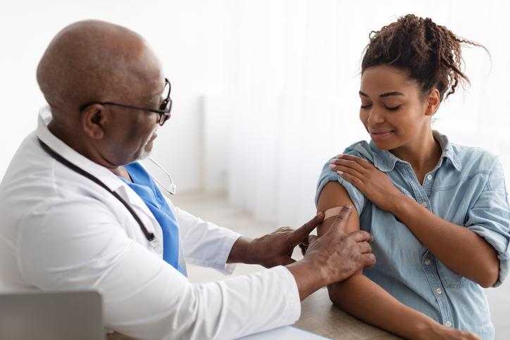 doctor putting band aid on woman