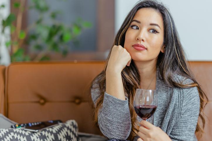 woman on couch drinking wine 