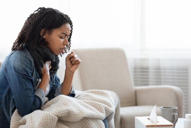 woman on couch coughing