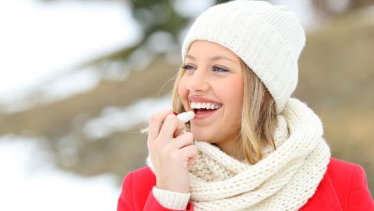 woman putting on chapstick