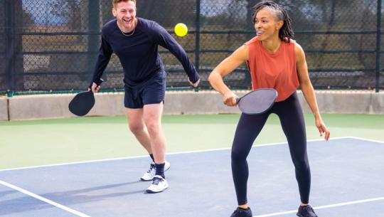 man and woman playing pickleball 