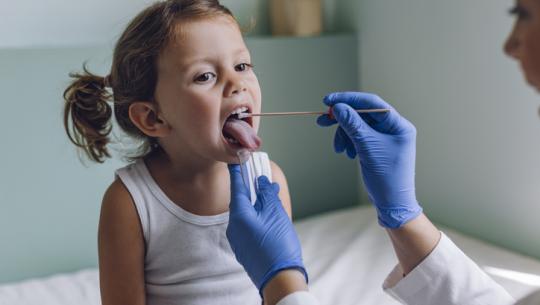 doctor checking child's throat