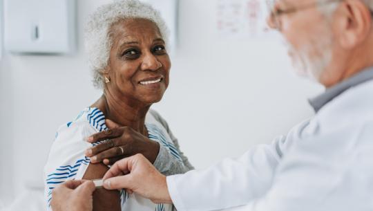 doctor putting band aid on woman