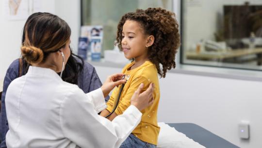 doctor listening to young girl's heart