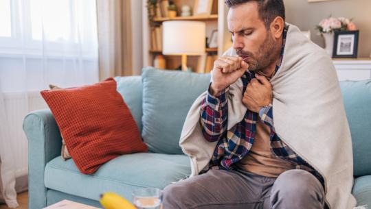 man coughing on couch