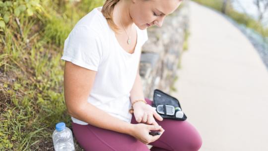 young woman checking insulin outside