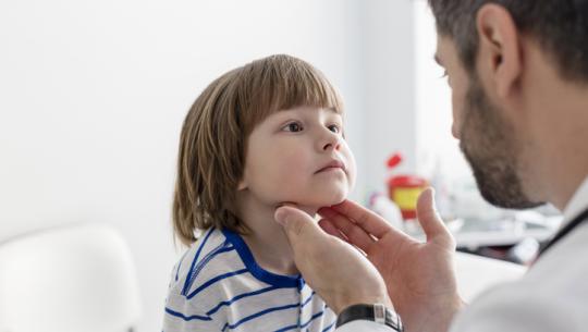 Doctor checking boy's tonsils