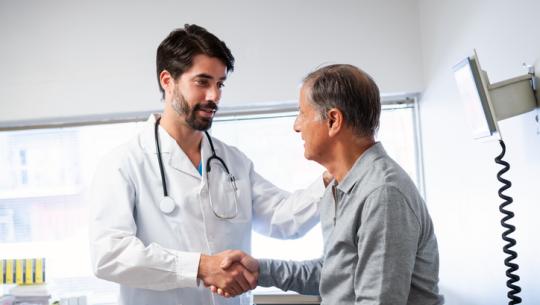 male doctor shaking male patient's hand