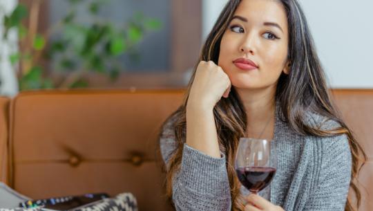 woman on couch drinking wine 