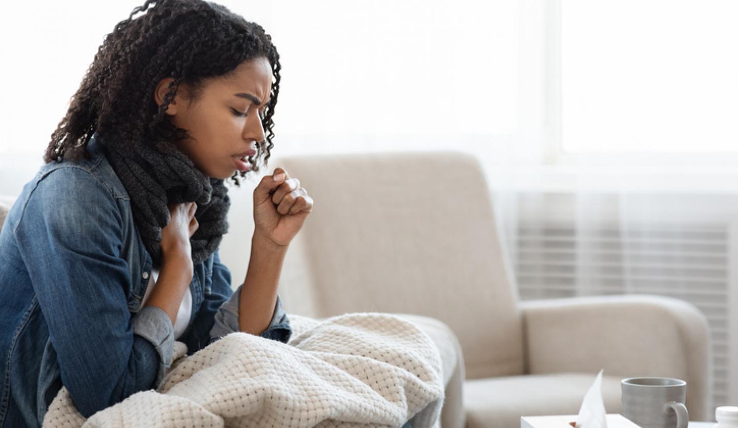 woman on couch coughing