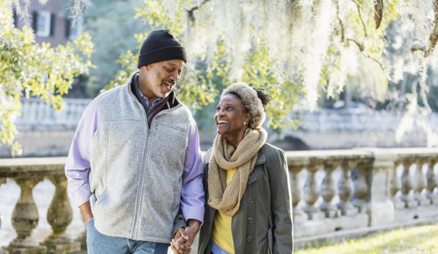 man and woman walking in park