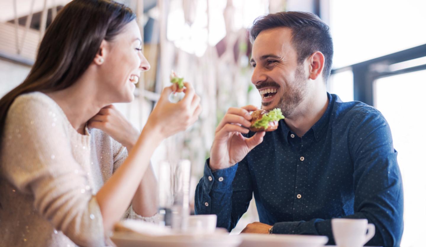 man and woman eating in cafe