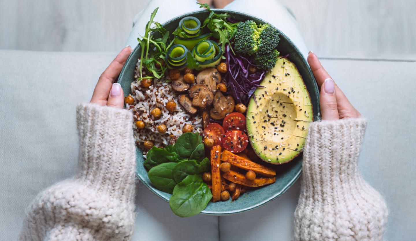 hands holding bowl of food