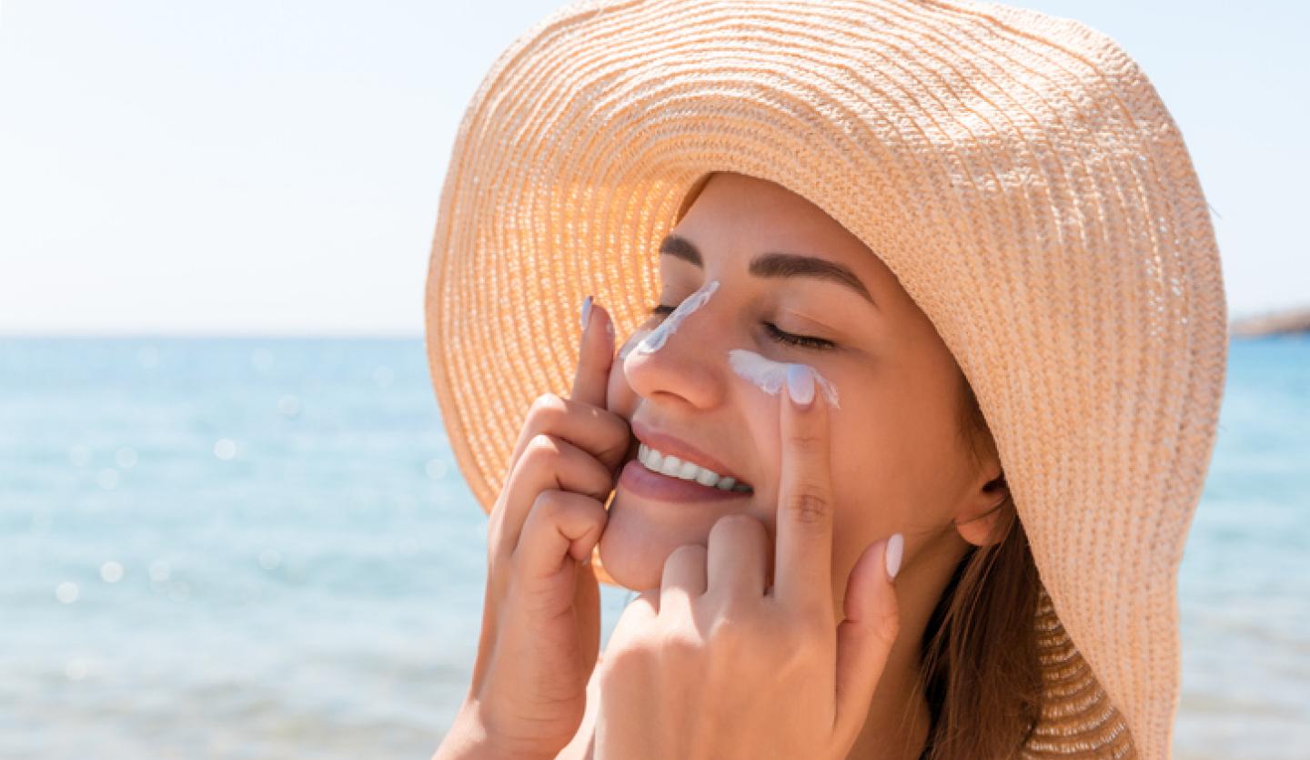 woman applying sunscreen at beach