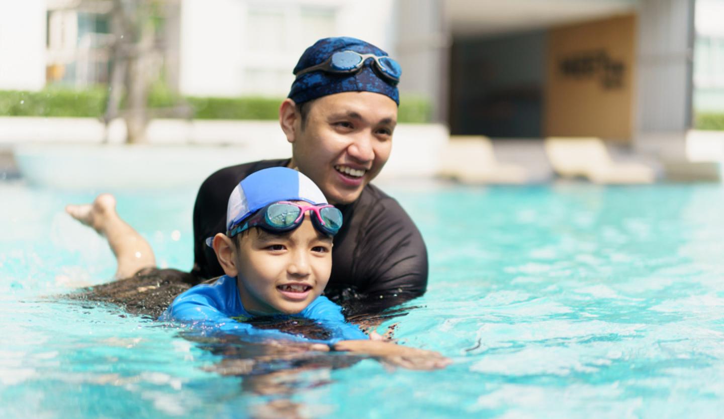 man and boy swimming in pool