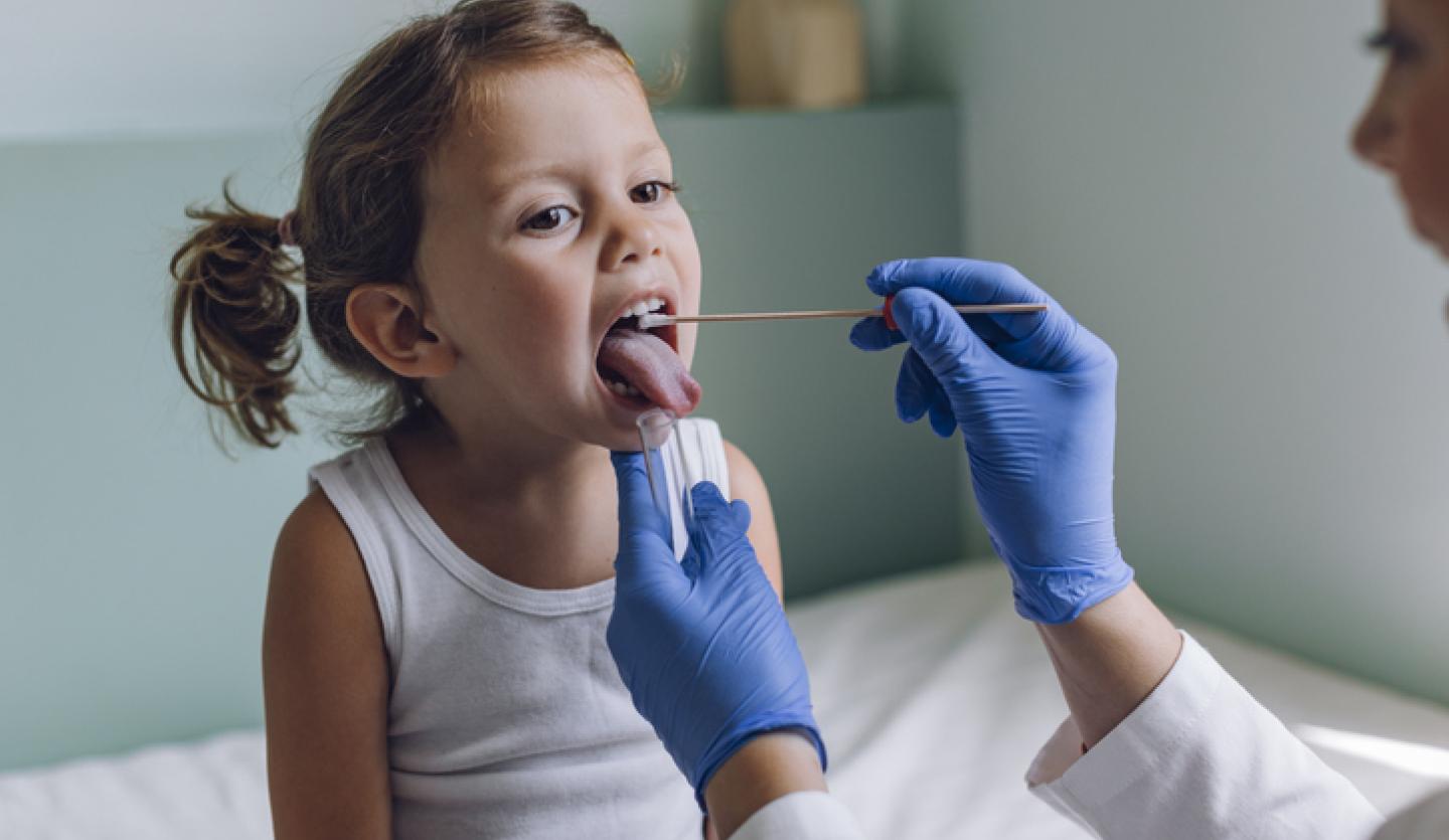 doctor checking child's throat