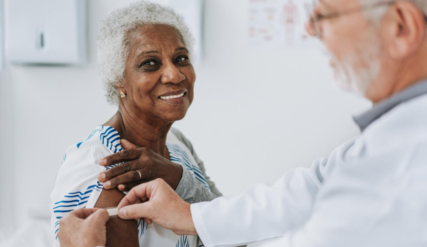 doctor putting band aid on woman