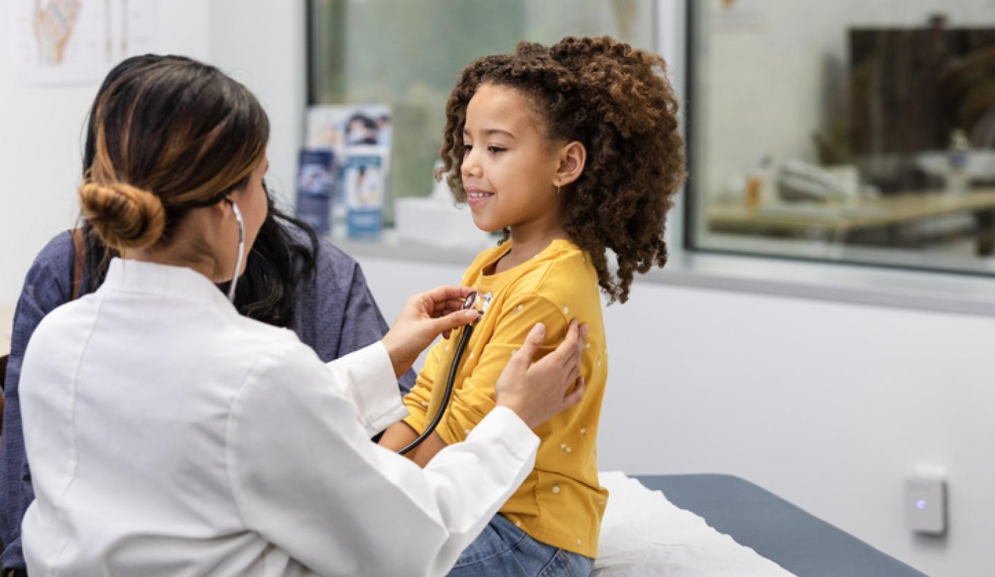 doctor listening to young girl's heart