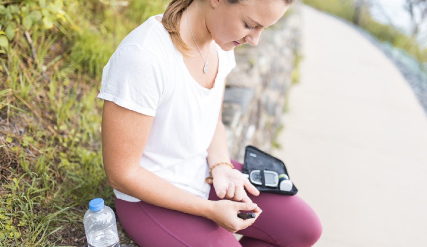 young woman checking insulin outside