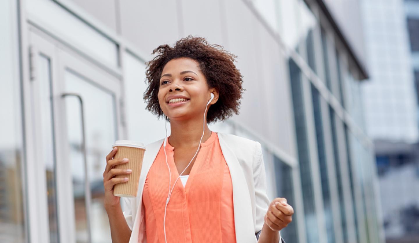 woman walking and holding coffee