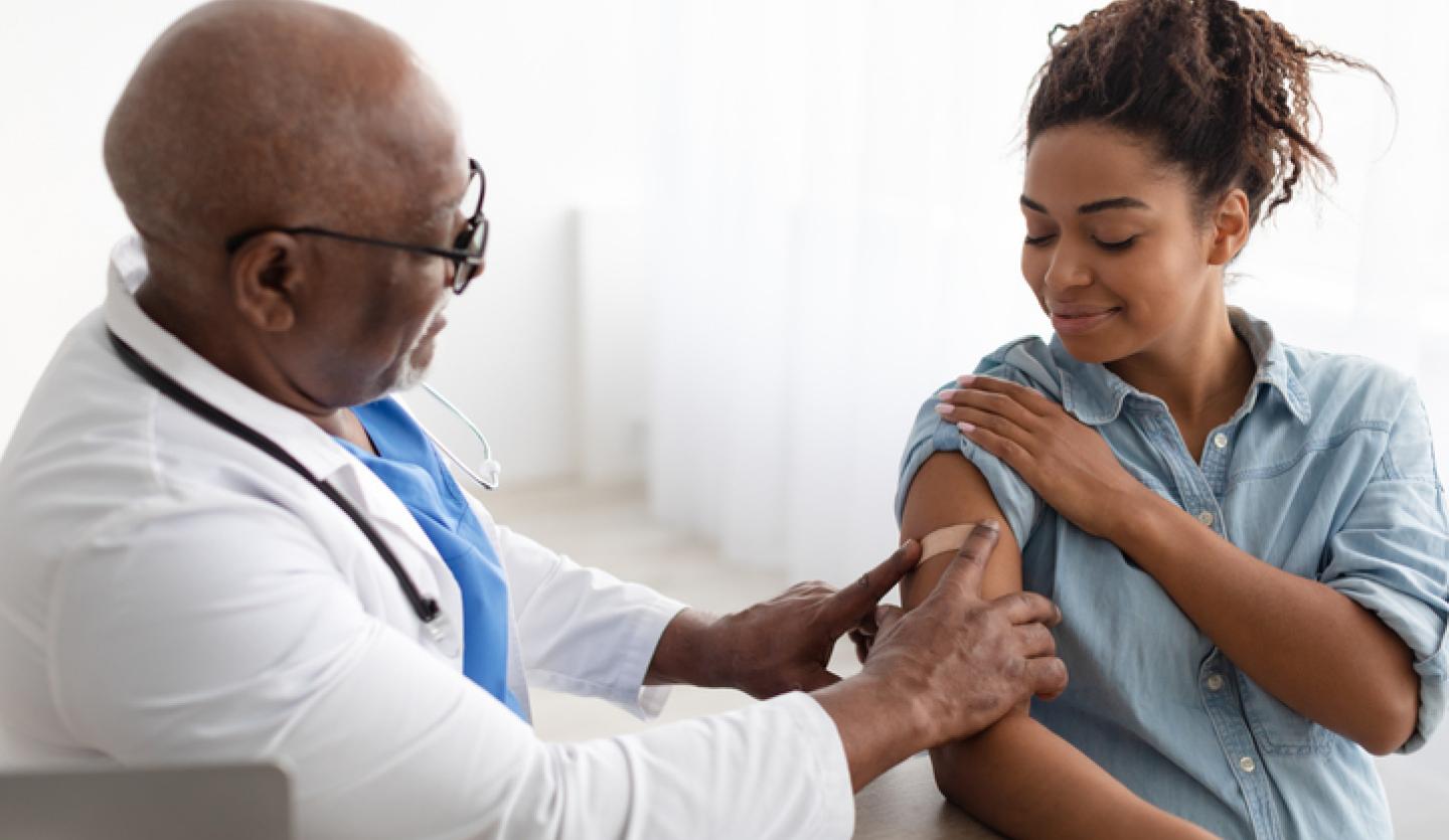 doctor putting band aid on woman