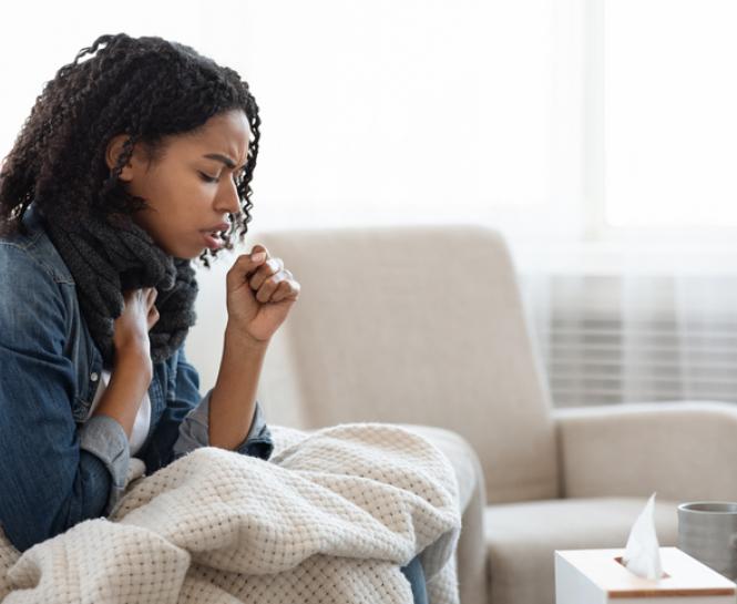 woman on couch coughing