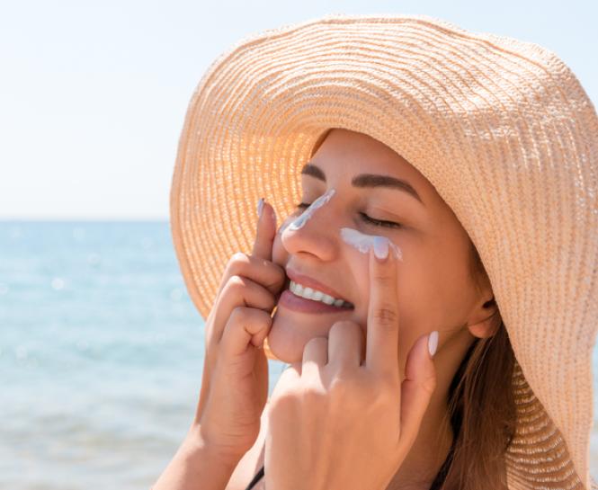 woman applying sunscreen at beach