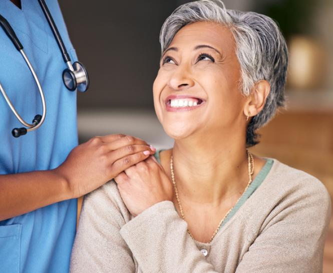 health care professional putting hand on woman smiling