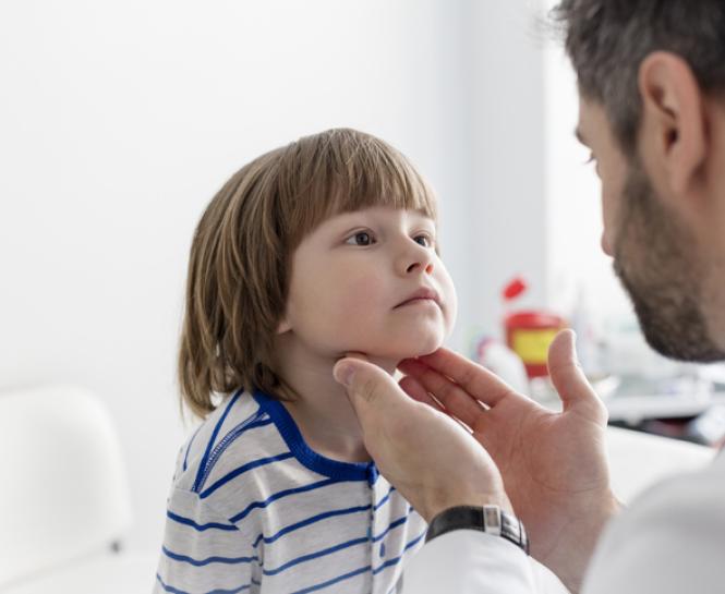 Doctor checking boy's tonsils