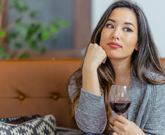 woman on couch drinking wine 