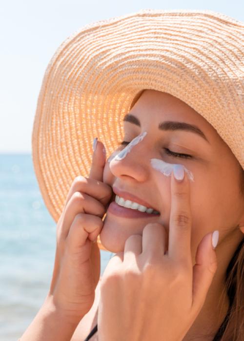 woman applying sunscreen at beach