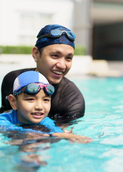 man and boy swimming in pool