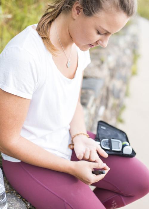 young woman checking insulin outside