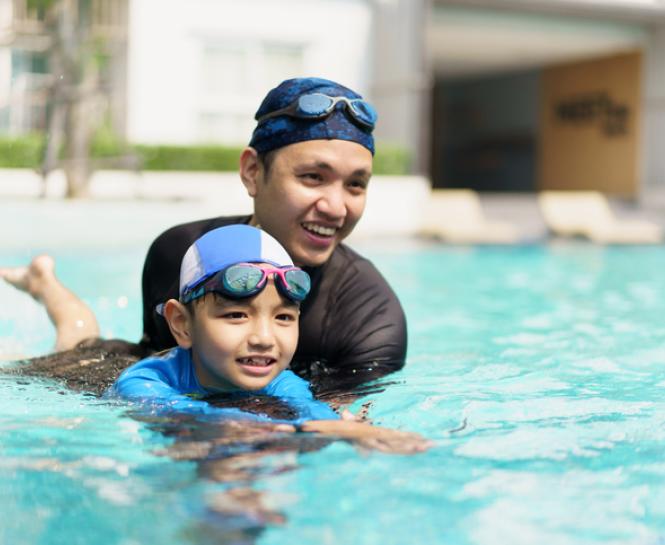 man and boy swimming in pool